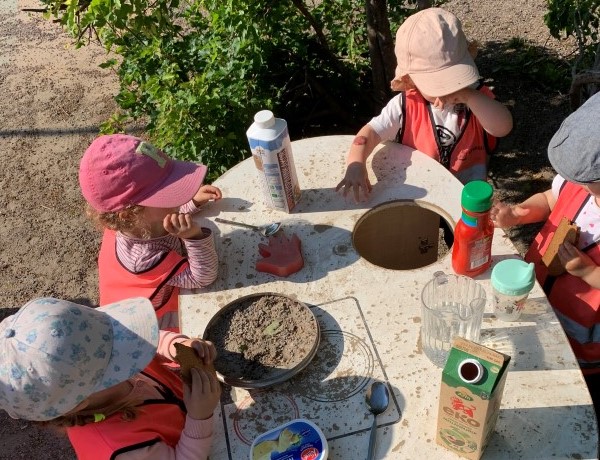 Barnen leker med sand på gården